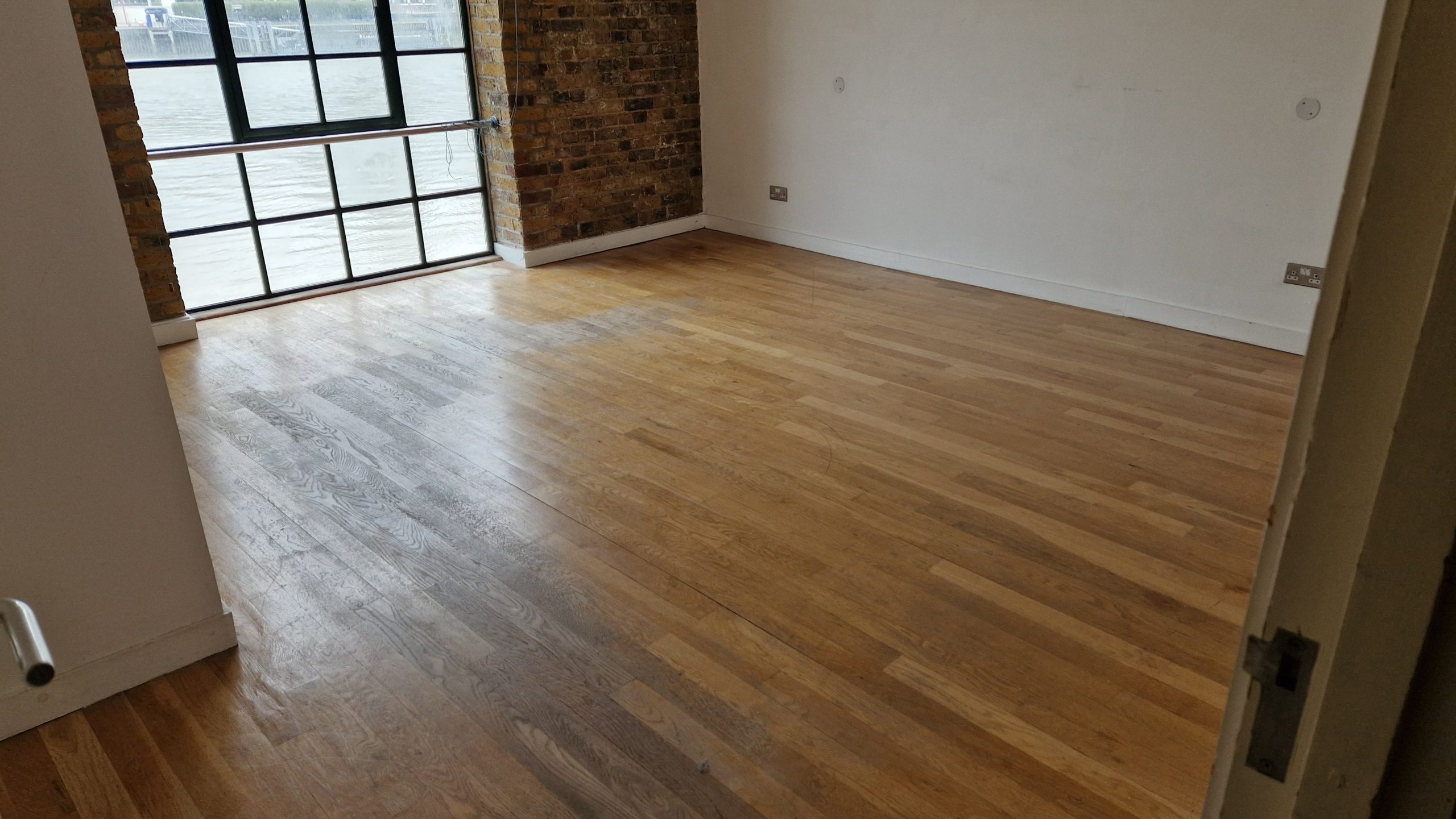 Hardwood Floor Refinishing in Upminster showing a tired solid oak strip hardwood living room floor before professional restoration